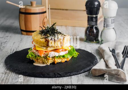 Sushi-Burger aus Reisbrot mit Lachs, Salat und Wasabi-Sauce. Sushi-Food Hybriden Trend. asiatische Stil glutenfrei. Stockfoto