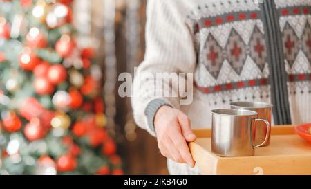 Gemütliches Zuhause weihnachtsfeier Mann heißen Drink Stahl Tassen Stockfoto