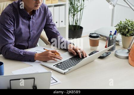 Zugeschnittenes Bildtechniker, der mit dem Kunden über einen Laptop kommuniziert Stockfoto