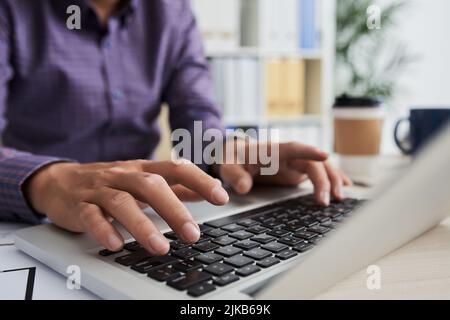 Nahaufnahme des Geschäftsmannes, der auf einem Laptop arbeitet Stockfoto