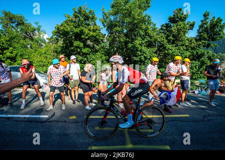 Radsportfans, die die Strecke auf der Alpe d'Huez während der Tour de France 2022 auffahren, und die Fahrer, die durch die Tour fahren Stockfoto