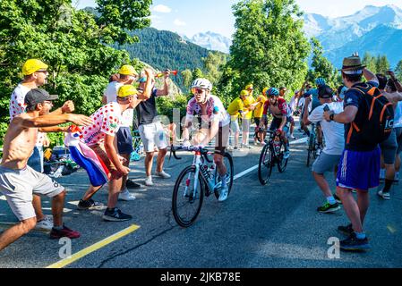 Radsportfans, die die Strecke auf der Alpe d'Huez während der Tour de France 2022 auffahren, und die Fahrer, die durch die Tour fahren Stockfoto