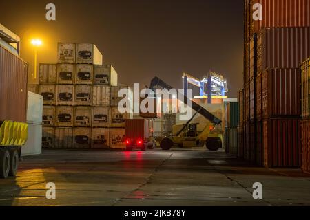 Industriehafen mit Containern. Stapel von Containern, Portalkran in der Nacht. Industrial Container Yard für Logistik Import Export Geschäft Stockfoto