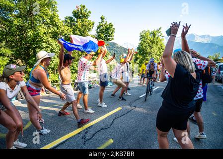 Radsportfans, die die Strecke auf der Alpe d'Huez während der Tour de France 2022 auffahren, und die Fahrer, die durch die Tour fahren Stockfoto