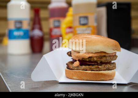 Street Food Käseburger an der Saucenstation im Imbissladen im Freien. Stockfoto