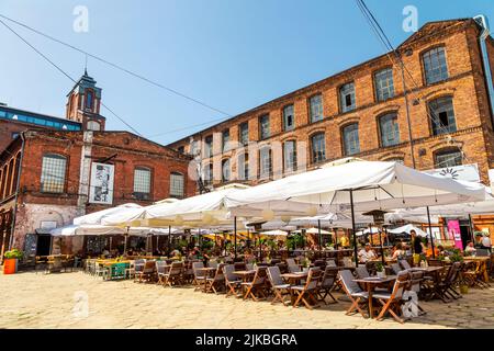 Die ehemalige Baumwollfabrik Ramisch aus dem späten 19.. Jahrhundert wurde in das PIOTRKOWSKA-Zentrum mit Restaurants und Geschäften in Lodz, Polen, umgewandelt Stockfoto