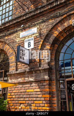 Bistro Pracowania Schild an der ehemaligen Ramisch-Baumwollmühle aus dem späten 19.. Jahrhundert, die in ein PIOTRKOWSKA-Zentrum mit Restaurants und Geschäften, Lodz, Polen, umgewandelt wurde Stockfoto