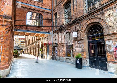 Die ehemalige Baumwollfabrik Ramisch aus dem späten 19.. Jahrhundert wurde in das PIOTRKOWSKA-Zentrum mit Restaurants und Geschäften in Lodz, Polen, umgewandelt Stockfoto