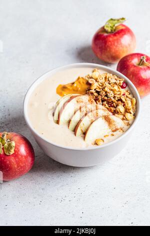 Apfelkuchen-Smoothie-Schüssel mit Müsli und Erdnussbutter. Herbstrezept. Vegane Küche. Stockfoto