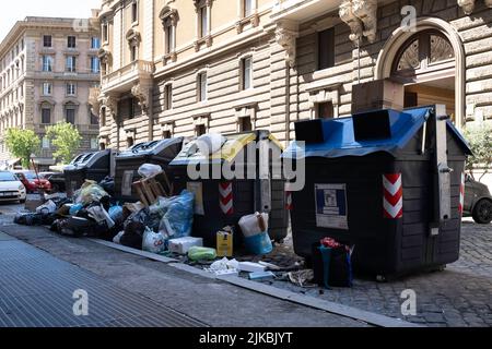 Überfließende Mülltonnen und Müllsäcke am Rande einer Straße in Rom. Stattliche Wohngebäude im Hintergrund. Gemischter Abfall Stockfoto