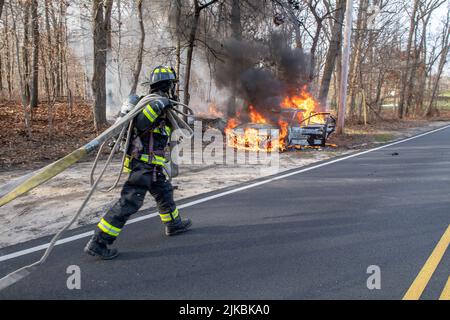 Mitglieder der East Hampton Fire Department löschen um 2:40 Uhr einen Arbeitsbrand in einem scheinbar verlassenen Fahrzeug vor der 404 Accabonac Road Stockfoto