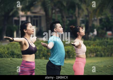 Junge Vietnamesen genießen frische Luft und Yoga üben im Freien Stockfoto