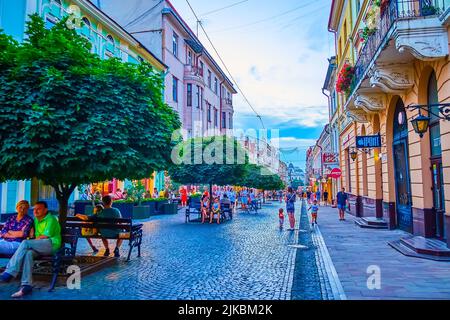 CZERNOWITZ, UKRAINE - 15. JULI 2021: Die Olga Kobylyanska Straße mit ihren Bänken ist ein großartiger Ort, um sich in der Altstadt am 15. Juli in Czernowitz zu entspannen Stockfoto