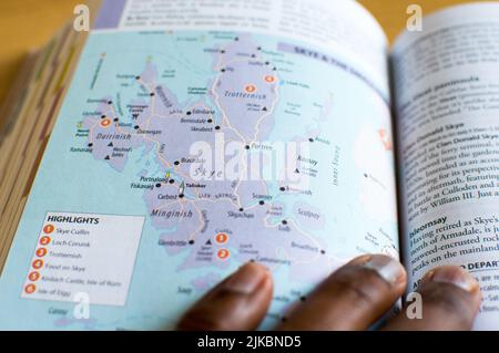 Männer lesen die schottischen Karten aus einem groben Reiseführer Stockfoto