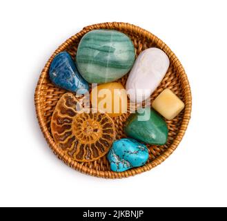 Cacholong, Chrysokrase, Opal, Rosenkalzit, Aventurin, Aragonit, Ammonit, Apatit und türkisfarbener Naturstein auf Rattanplatte isoliert auf weißem Bac Stockfoto