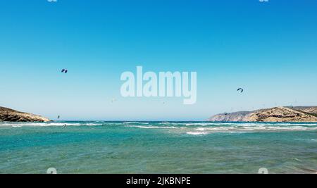 Weite Sicht auf Kitesurfer, die am Strand von Prasonisi fliegen Stockfoto