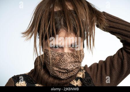 Frau, die Spaß mit einer Maske trägt braune Maske, schützt sich vor covid Stockfoto