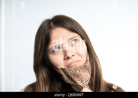 Frau, die Spaß mit einer Maske trägt braune Maske, schützt sich vor covid Stockfoto