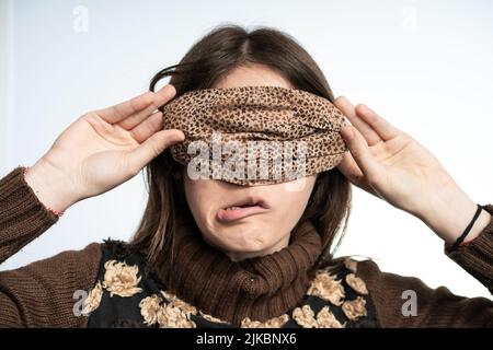 Frau, die Spaß mit einer Maske trägt braune Maske, schützt sich vor covid Stockfoto