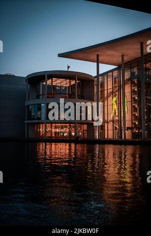Eine vertikale Aufnahme eines modernen Penthouse mit seiner Spiegelung am Pool bei Sonnenuntergang Stockfoto