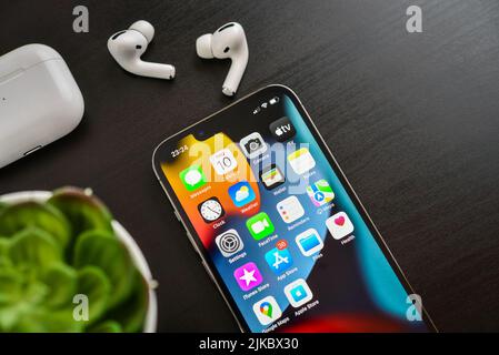 KIEW, UKRAINE - 10. FEBRUAR 2022: Ausgepacktes neues Apple iPhone 13 Pro Space Grey mit AirPods Pro Kopfhörern auf schwarzem Hintergrund. Stockfoto