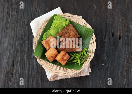 Tahu Tempe Bacem. Tofu und Tempeh mit süßen Gewürzen. Draufsicht auf Holzhintergrund Stockfoto