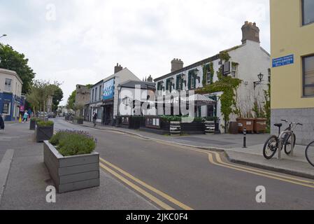 In der Castle Street, der Hauptstraße von Dalkey, Leinster, Irland, können Sie Menschen stöbern, einkaufen und essen. Juli 2022 Stockfoto