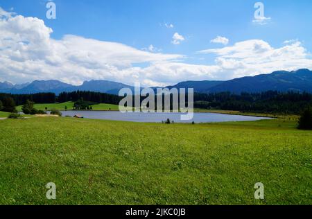 Wanderweg mit Blick auf den malerischen Attlesee in den bayerischen Alpen, Nesselwang, Allgäu oder Allgau, Deutschland Stockfoto