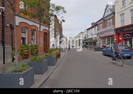 In der Castle Street, der Hauptstraße von Dalkey, Leinster, Irland, können Sie Menschen stöbern, einkaufen und essen. Juli 2022 Stockfoto