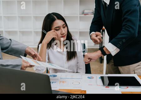 Junge asiatische Frau, die mit übermäßiger Arbeit unzufrieden ist Stockfoto