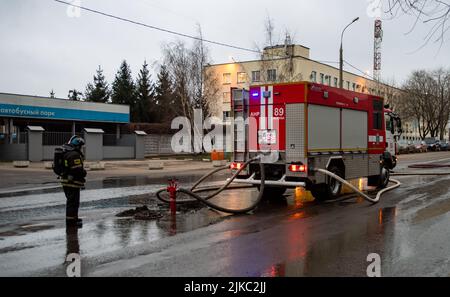 13. Dezember 2019, Moskau, Russland. Ein Feuerwehrmann beobachtet, wie ein Feuerwehrauto Wasser aus einem Hydranten zieht. Stockfoto