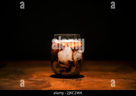 Ein erfrischender, spritzig weißer russischer Cocktail mit Wodka und Creme auf einem dunklen Holztisch Stockfoto