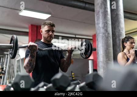 Junge kaukasische Mann und Frau tun Lift Gewichte in der Turnhalle, Training, Lifestyle und Sport-Konzept, Kopie SPAC Stockfoto
