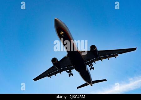 Die Silhouette eines Passagierflugzeugs, das vor dem Hintergrund des Sonnenuntergangs landet. Stockfoto