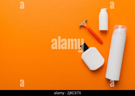 Rasierer-Set. Schermaschine, Handtuch, Lotion und Rasierschaum auf farbigem Hintergrund. Herren Bad Accessoires Draufsicht. Stockfoto