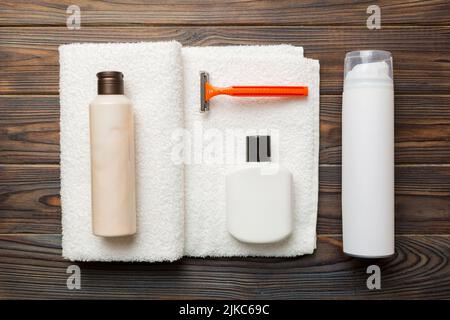 Rasierer-Set. Schermaschine, Handtuch, Lotion und Rasierschaum auf farbigem Hintergrund. Herren Bad Accessoires Draufsicht. Stockfoto