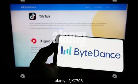 Person, die Smartphone mit dem Logo des chinesischen Technologieunternehmens Bytedance Ltd. Auf dem Bildschirm vor der Website hält. Konzentrieren Sie sich auf die Telefonanzeige. Stockfoto