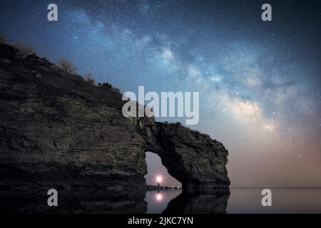 Eine Luftaufnahme des natürlichen Kalksteinbogens von Durdle Door auf dem Hintergrund der glückseligen Milchstraße am Himmel Stockfoto