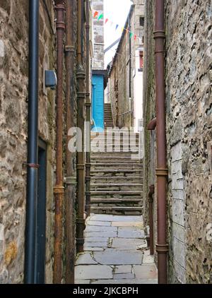 Steile Steintreppen in einem sehr engen Fußgängerweg zwischen Gebäuden in Lerwick, Shetland, Großbritannien. Stockfoto