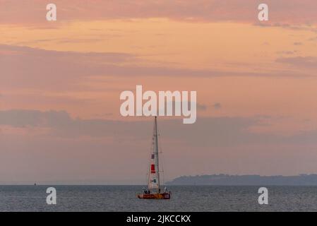 Qingdao Team Yacht im Morgengrauen vor dem Southend Pier in der Themse Mündung nach dem Clipper Round the World Yacht Rennen. Am frühen Morgen roter Himmel Stockfoto