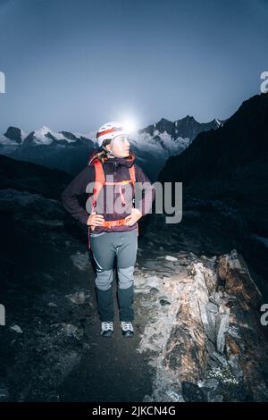 Portrait einer Kletterin vor Sonnenuntergang mit Stirnlampe, die Spuren findet Stockfoto