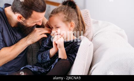 Glückliche Familie Freizeit Vater kitzelt Tochter Stockfoto