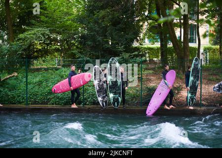 Surfer warten auf die Eisbachwelle im Zentrum von München Stockfoto