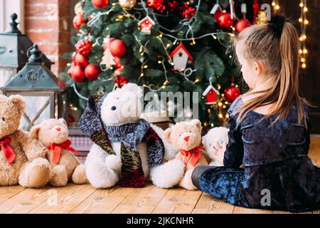 weihnachtsabend kleines Mädchen spielen Teddybären Stockfoto