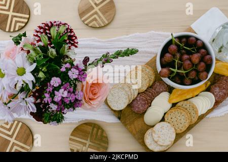 Charcuterie-Brett und Trauben auf Holztisch Stockfoto