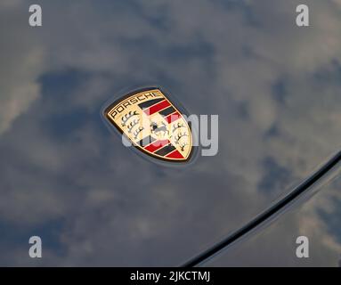 Nahaufnahme eines Porsche-Emblems auf der Motorhaube eines Porsche 911 Carrera GTS. Stockfoto