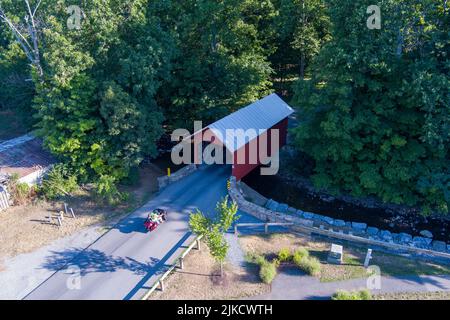 Ein Motorrad nähert sich einer überdachten Brücke in Frederick County, Maryland Stockfoto