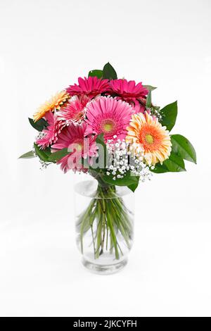 Ein farbenfroher Strauß mit Gerberas in einer Glasvase Stockfoto