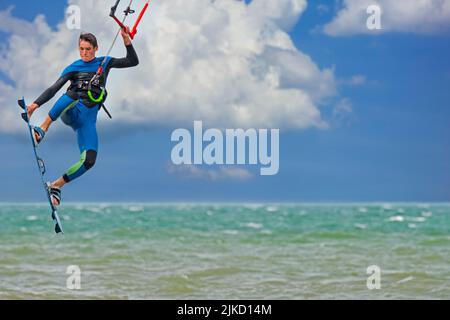 Kitesurfen zeigt Kiteboarder / Kitesurfer an einem windigen Tag auf einem Twintip Board Springen an der Nordsee. Digitales Composite Stockfoto