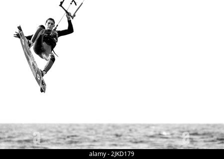 Kitesurfen zeigt Kiteboarder / Kitesurfer an einem windigen Tag auf einem Twintip Board Springen an der Nordsee Stockfoto